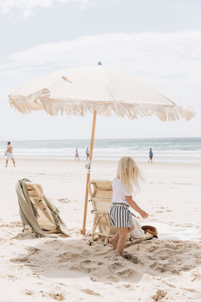 Girl under umbrella on the beach